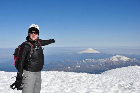 No alto do vulcão Lanín, a Ana aponta o vulcão Villarrica, 1.000 metros abaixo de nós e que subimos três dias atrás (na região de Junín de Los Andes, no sul da Argentina)